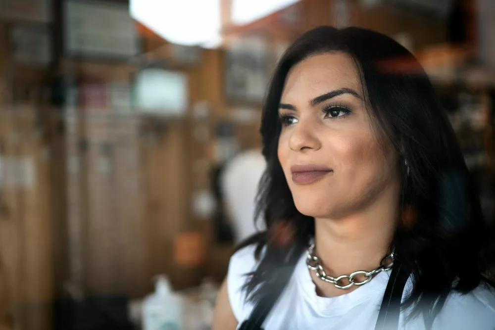 Transgender woman looking outside of a window